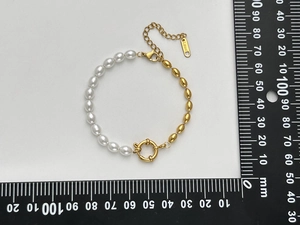 Detail of 18K gold plated stainless steel bracelet with oval pearls and lobster clasp