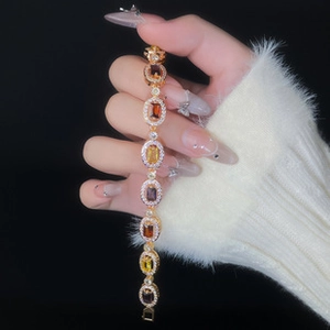 Macro shot of gold-plated bracelet with multi-color gemstones and micro-pave crystals