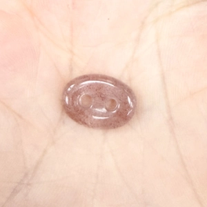 Macro detail of polished pink strawberry crystal pig nose button with natural textures