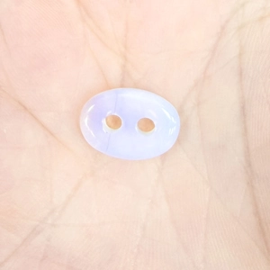 Macro shot of a lavender translucent quartz bead with a dual-hole pig nose buckle design
