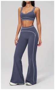 Détail d'un ensemble de yoga bleu fumée avec bordures blanches et pantalon évasé