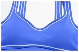 Detail of blue yoga bra with contrast stitching and three white stripes on shoulder straps