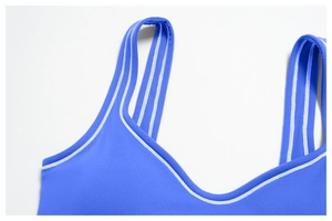 Detail of blue sports bra with V-neckline and white contrast stripes on wide straps