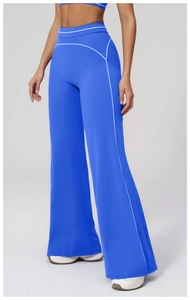 Detail showing high-waisted flared fitness pants in bright blue with contrast stitching