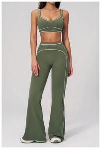 Close-up of olive green high-waist flared yoga pants and sports top with white contrast stitching