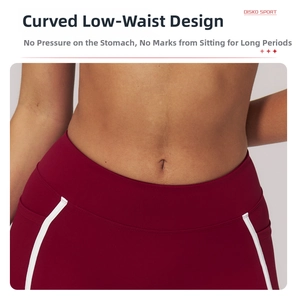 Detail of dark red yoga shorts featuring curved low-waist design and white side stripes