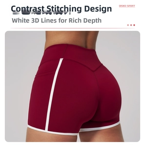 Detailed view of high-stretch burgundy yoga shorts with white contrast stitching detail