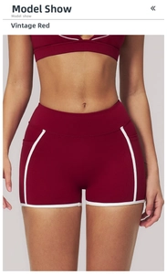 Close-up of retro red yoga shorts with contrast white piping and functional side pockets