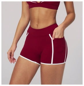 Detailed view of burgundy gym shorts featuring white contrast trim and side pockets