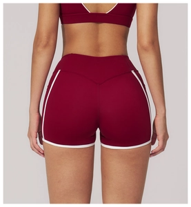 Detail of high-waist yoga shorts with burgundy fabric and white contrast trim for fitness