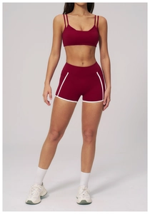 Detail of burgundy yoga set featuring contrast white piping and functional side pockets