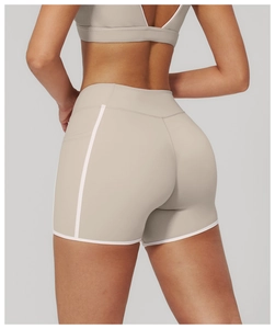 Detail view of high-waisted yoga shorts with contrast white piping and matte texture