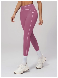 Detail of high-waist yoga leggings with contrast white stitching in plum purple hue