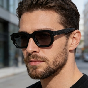 Detail of matte black rectangular sunglasses with arrow-shaped relief pattern on temple