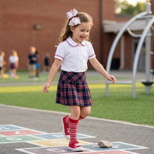 Close-up of a large white bow hairclip with red edges on a girl in school uniform