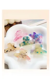 Set of 6 colorful acetate hair claws with marble textures in a white floral tray