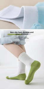 Detail of white cotton socks featuring a non-slip green heel and breathable mesh texture