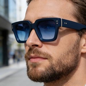 Gros plan de lunettes de soleil carrées rétro avec monture bleu marine et verres dégradés