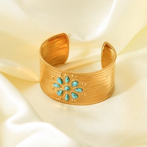 Detailed macro view of 18K gold plated wide cuff bangle with turquoise gemstone flower