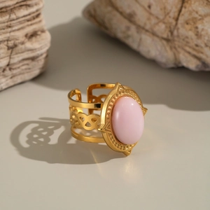 Detailed macro view of the vintage gold-toned ring with a pink oval gemstone and hollow design