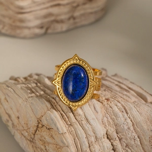 Macro detail of gold-plated stainless steel ring with oval lapis lazuli on stone
