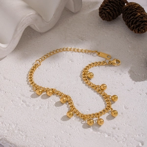 Detail of 18K gold-plated stainless steel curb chain bracelet with gold ball charms