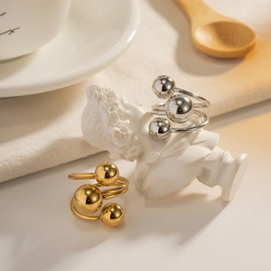 Minimalistischer offener Edelstahlring mit drei polierten Metallkugeln in schickem Goldfinish