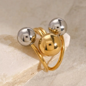 Details eines minimalistischen Goldrings mit drei Metallkugeln auf einem Steinsockel