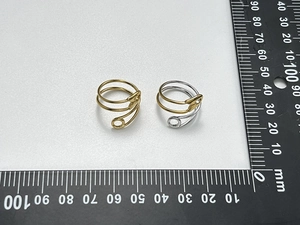 Macro view of geometric safety pin rings in gold and silver with scale measurement