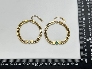 Vue détaillée des bracelets à maillons cubains dorés 18K avec pierres émeraude et claires