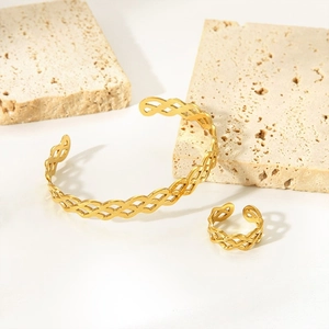 Detail of 18K gold plated hollow braided cuff bracelet and matching ring on stone