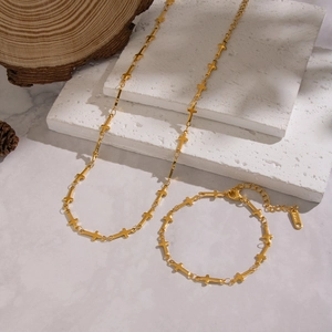 Détail de l'ensemble collier et bracelet croix en acier inoxydable plaqué or 18 carats