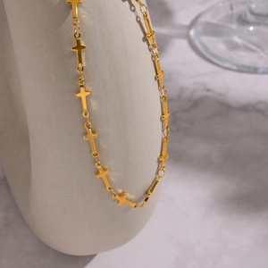 Détail du collier à maillons croisés en acier inoxydable plaqué or 18 carats sur support