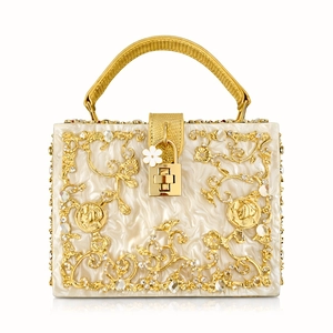 Detail of luxury box bag with golden floral metal hollow design and pearl texture