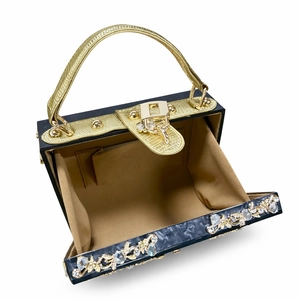 Detail of evening clutch with marble pattern, golden floral rhinestones and brown lining