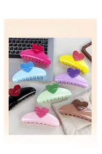 Close-up of heart-shaped hair claw clips in eight vibrant colors with glossy finish