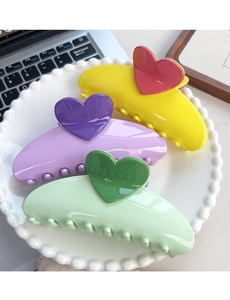 Detailed view of colorful large heart hair claws in yellow, purple and mint green set
