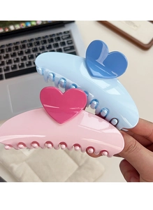 Macro detail of large heart claw hair clips in pastel blue and pink with glossy finish