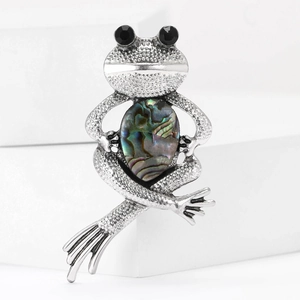 Macro shot of frog brooch with vintage silver finish and iridescent abalone shell inlay