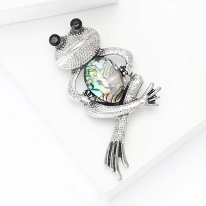 Vintage silver frog brooch with colorful abalone shell inlay on white background