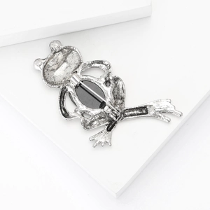 Vintage silver frog brooch for women with black shell inlay and safety pin on white background