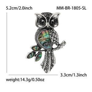 Fashionable owl brooch featuring natural abalone shell wings and black gem eyes