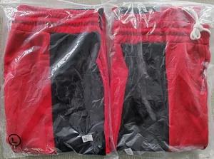 Detail of color-block joggers in black and red with elastic waist and white drawstring
