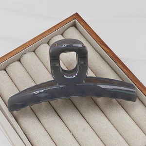 Macro detail of large 13cm dark gray translucent shark hair claw clip in a jewelry box