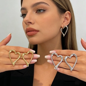 Chic hollow heart-shaped metal stud earrings in gold and silver finish on a model