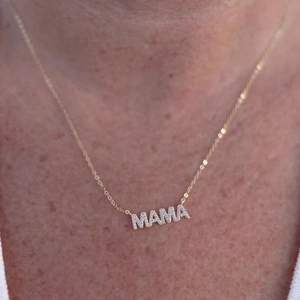 Close-up of a gold MAMA letter pendant necklace with sparkling micro-pave crystals
