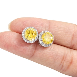 Classic halo stud earrings featuring a round yellow zircon set in polished sterling silver