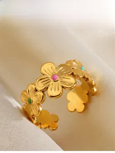 Detailed close-up of golden stainless steel rings with colorful enamel flower patterns