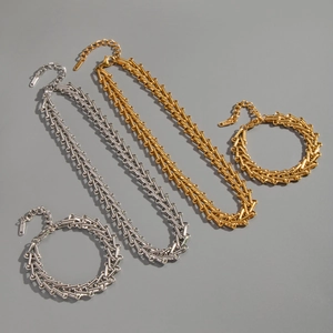Detailed view of gold and silver industrial chain necklaces and bracelets in stainless steel