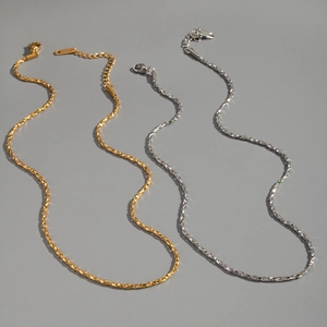 Close-up of twisted chain necklaces in gold and silver with lobster clasp and adjustable links